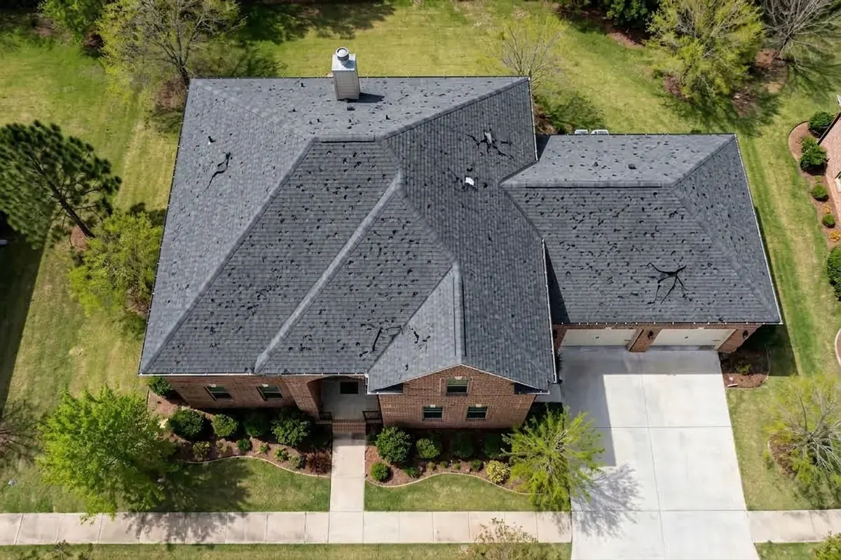 Hail-damaged roof with bruised shingles and granule loss before replacement in Spring, TX